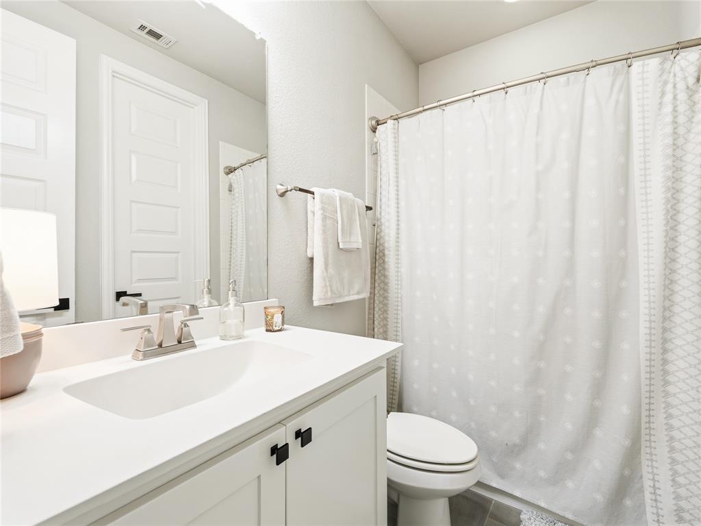 15340 Crape Myrtle Road Frisco, TX 75035 - Photo 34 of 40 Bathroom featuring a vanity with an integrated sink, brushed nickel faucet, and white cabinetry with matte black hardware