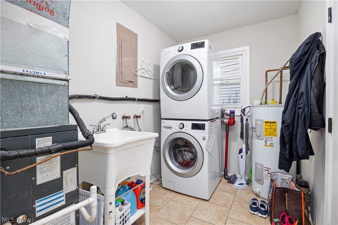 184 Sunset Road Avon Lake, OH 44012 - Photo 28 of 35 Clothes washing area featuring stacked washer and clothes dryer, light tile floors, electric water heater, and washer hookup