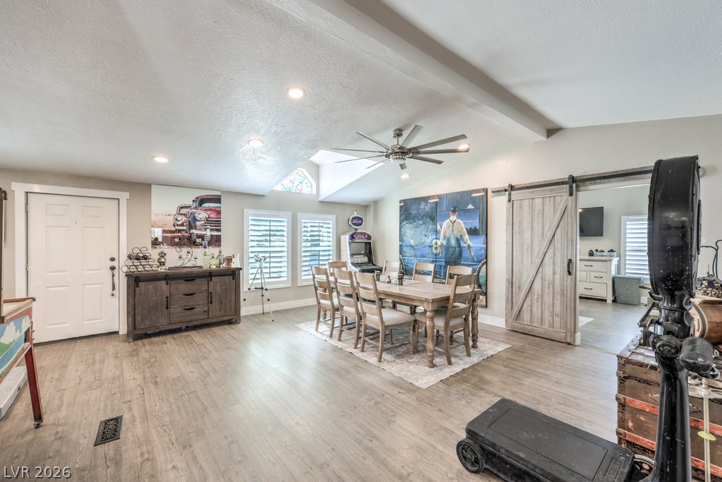4375 Pinwheel Street Logandale, NV 89021 - Photo 13 of 52 Bright, open-concept dining area with light wood flooring and unique barn-style door.