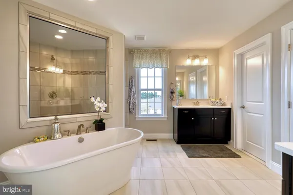 a spacious bathroom with a tub sink shower and mirror