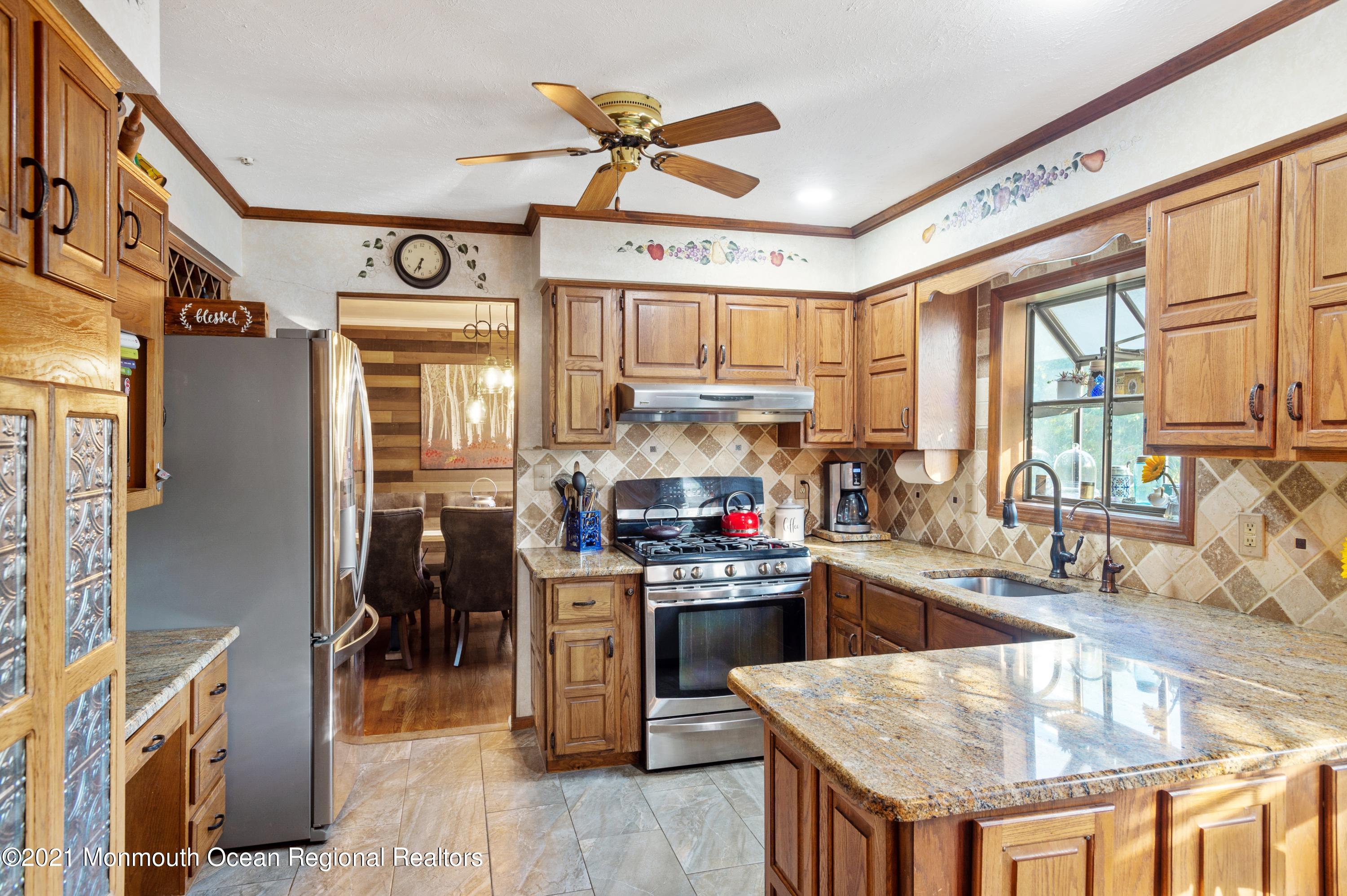 131 Bar Harbor Road Freehold, NJ 07728 - Photo 4 of 31 a kitchen with stainless steel appliances granite countertop a sink dishwasher a stove and a refrigerator with wooden floor