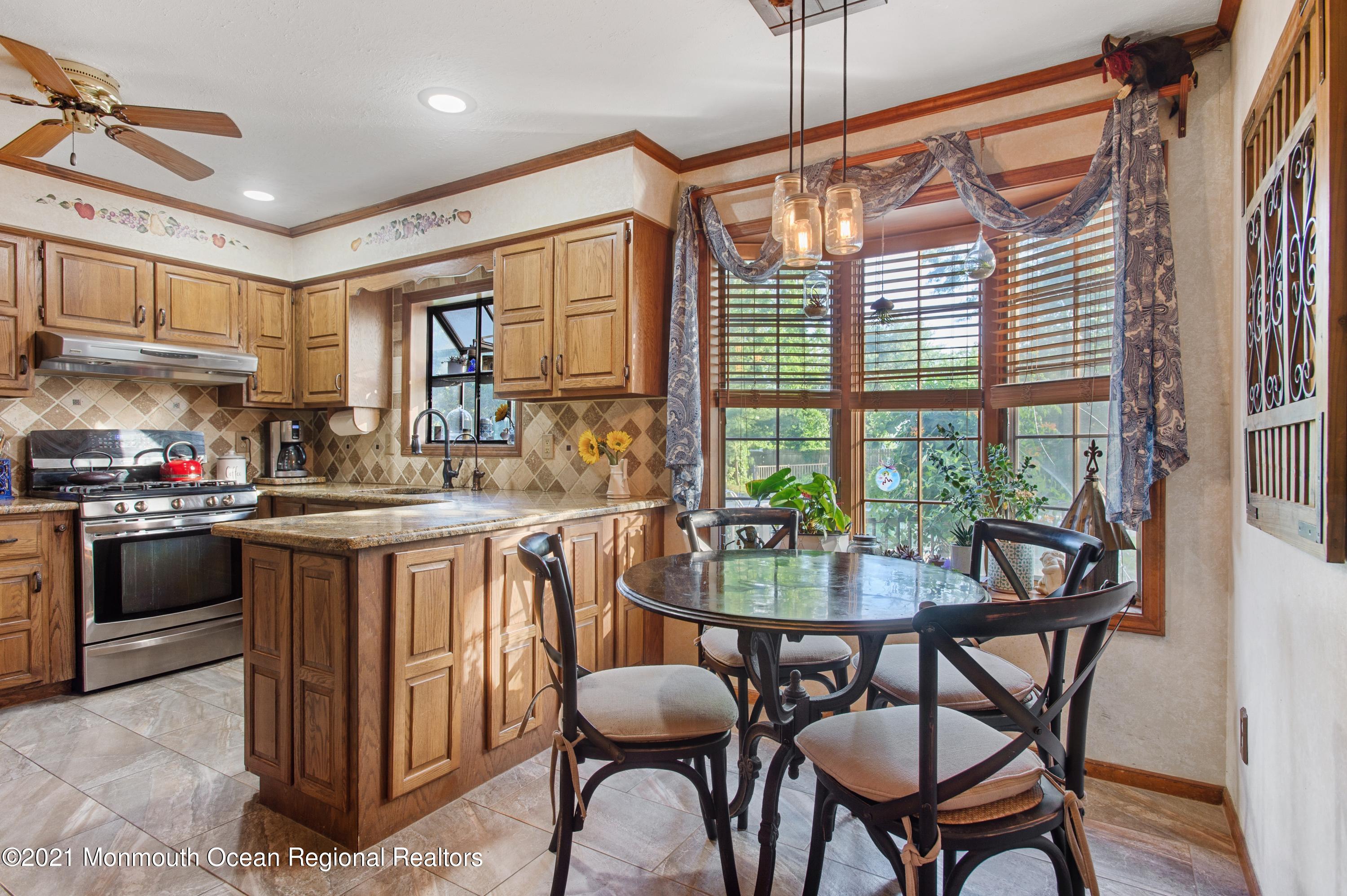 131 Bar Harbor Road Freehold, NJ 07728 - Photo 5 of 31 a kitchen with a table chairs stove and cabinets