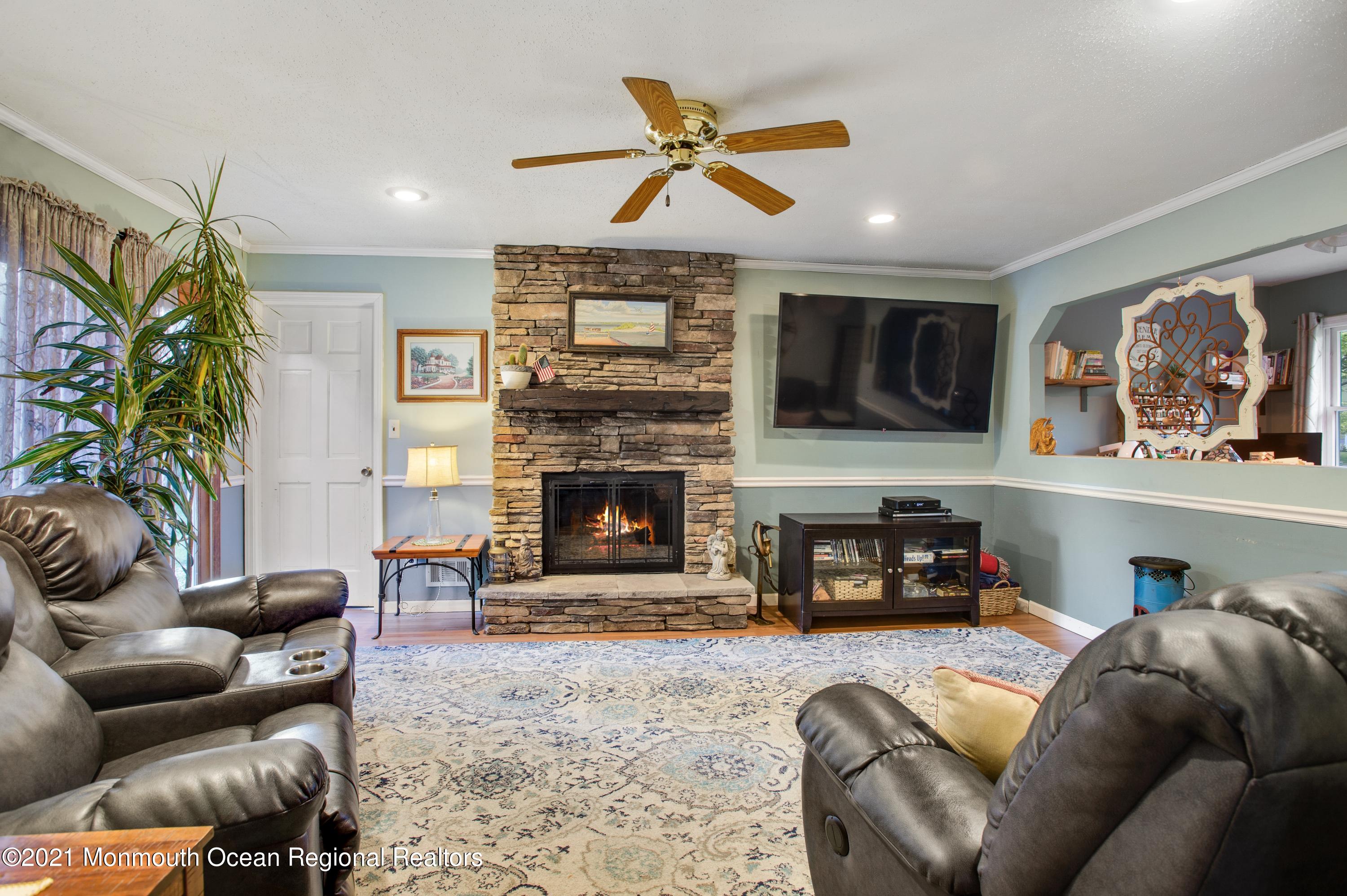 131 Bar Harbor Road Freehold, NJ 07728 - Photo 8 of 31 a living room with furniture a flat screen tv and a fireplace