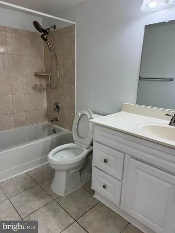 a bathroom with a toilet sink vanity tub and shower