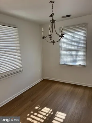 a view of a room with wooden floor and windows