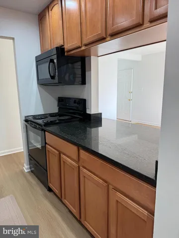 a kitchen with granite countertop cabinets and black appliances