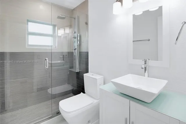 a bathroom with a sink a toilet and shower