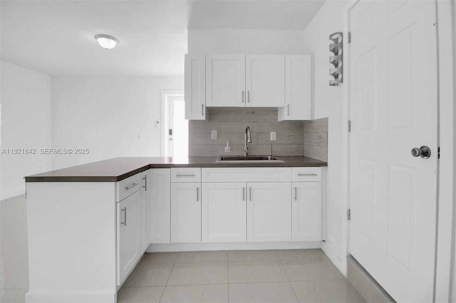 15251 Southwest 56th Terrace Miami, FL 33193 - Photo 17 of 29 a kitchen with a sink and cabinets