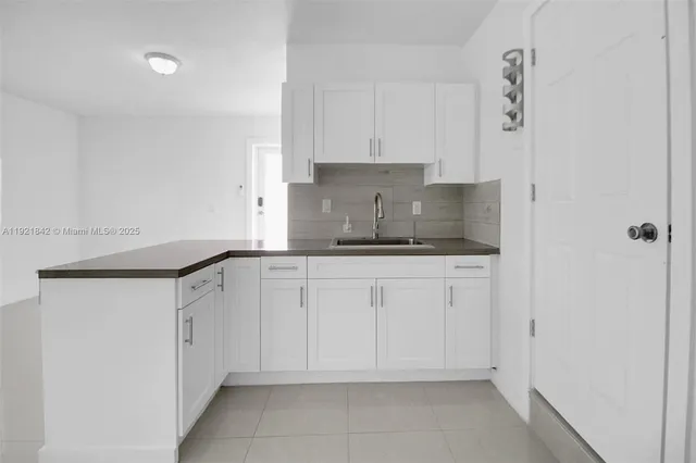 a kitchen with granite countertop white cabinets and stainless steel appliances