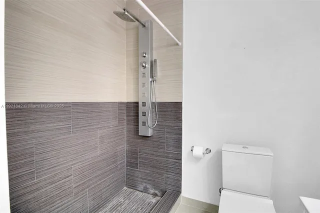 a bathroom with a toilet and a shower