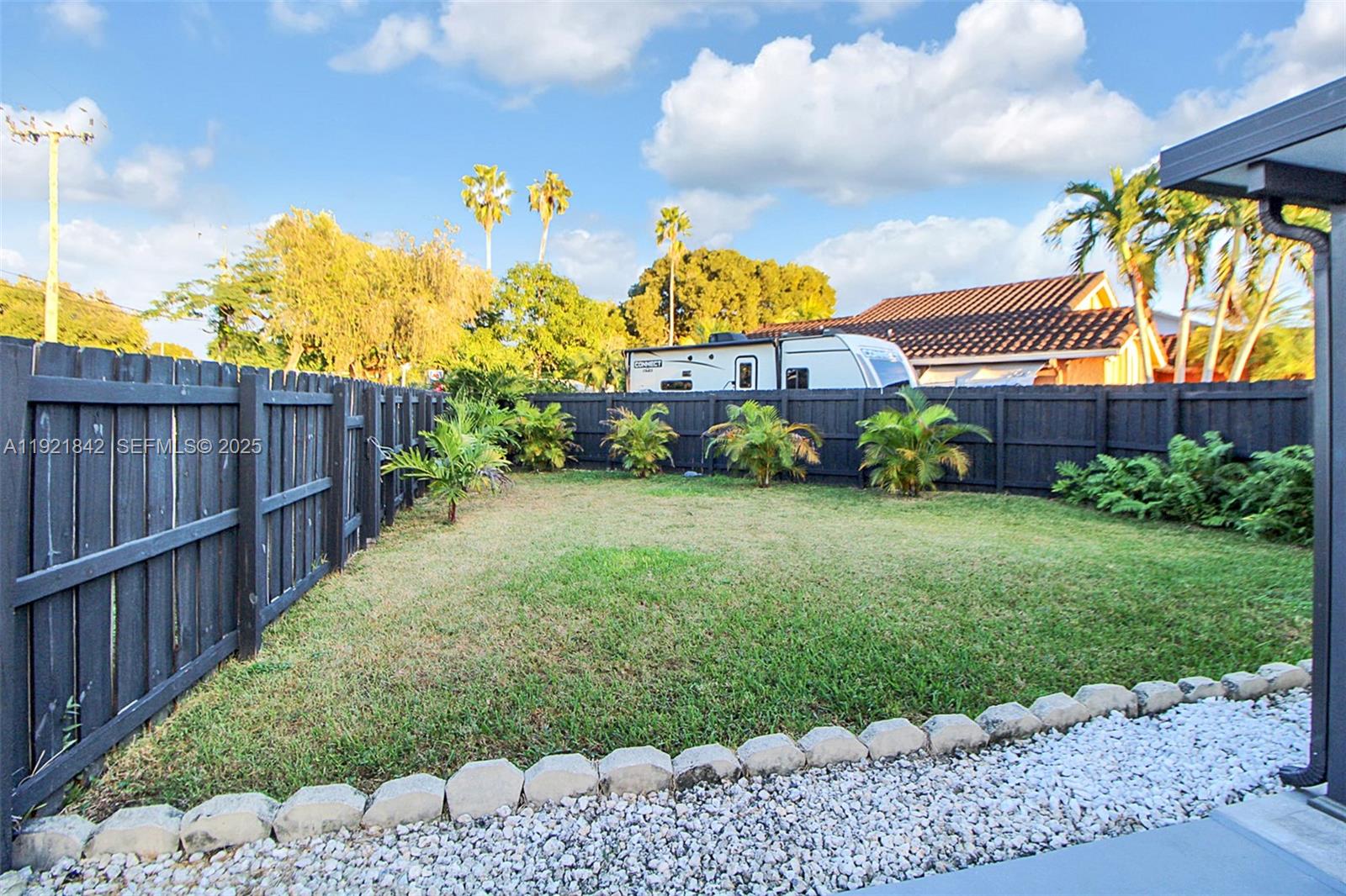 15251 Southwest 56th Terrace Miami, FL 33193 - Photo 27 of 29 a view of a back yard with flower plants and wooden fence