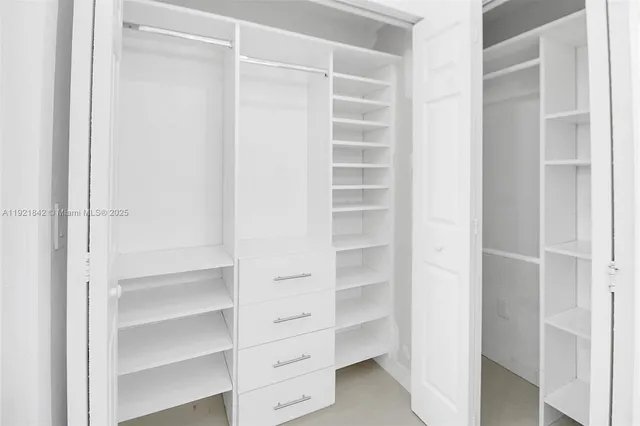 a view of walk in closet with empty racks