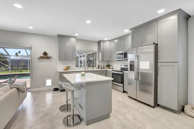 a kitchen with stainless steel appliances granite countertop a refrigerator and a sink