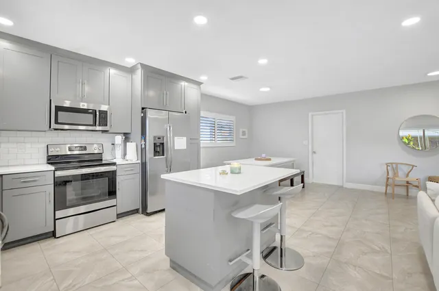 a kitchen that has a sink a stove and chairs