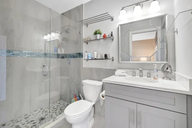 a bathroom with a sink a toilet and shower