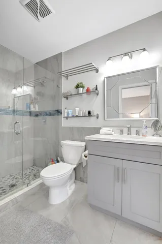 a bathroom with a sink toilet vanity and shower