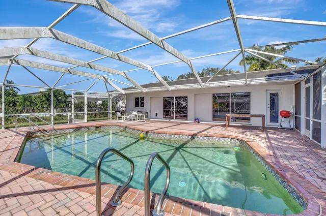 a view of a patio with a table and chairs under an umbrella