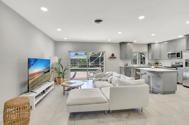 a living room with furniture a floor to ceiling window and a flat screen tv
