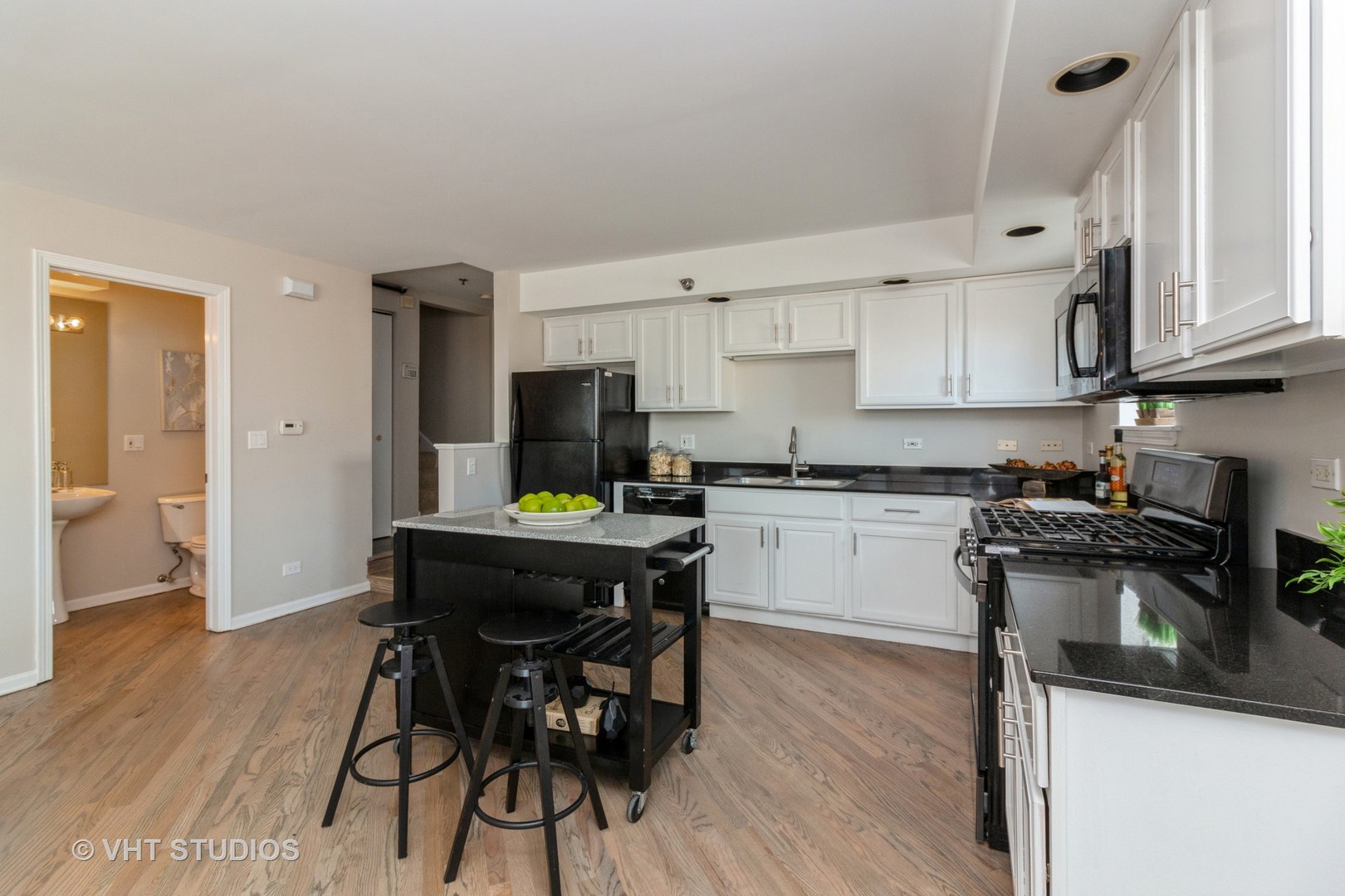 1830 Ridge Avenue, Unit 5C Evanston, IL 60201 - Photo 2 of 11 a kitchen with stainless steel appliances kitchen island granite countertop a table chairs stove and white cabinets