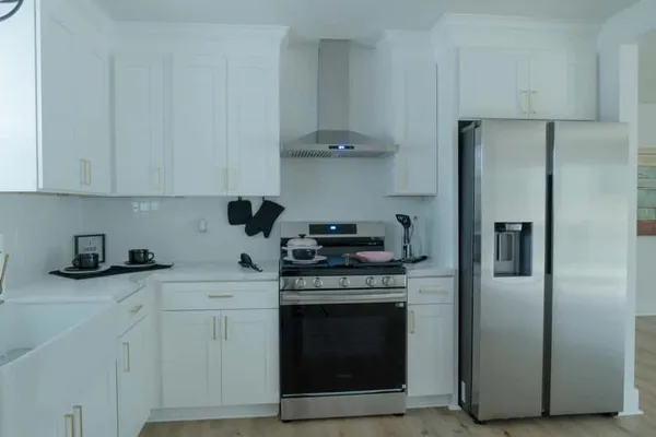 a kitchen with stainless steel appliances granite countertop a stove a refrigerator and a sink