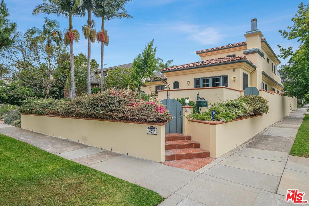 a front view of a house with a yard and potted plants