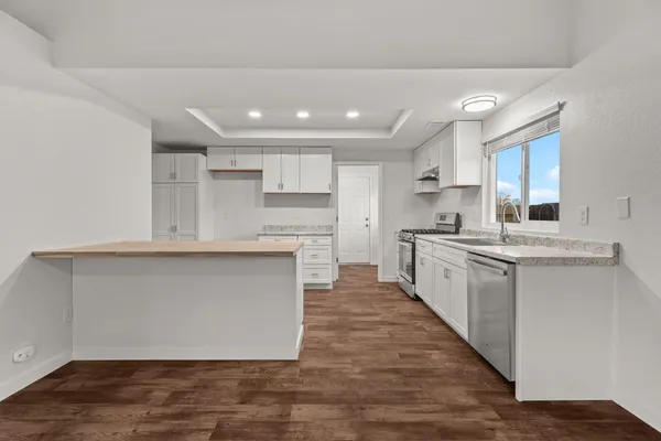 a large kitchen with cabinets and wooden floor