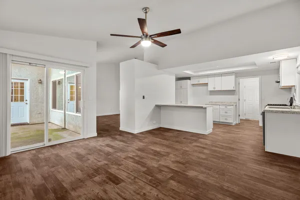 a view of empty room with wooden floor and ceiling fan