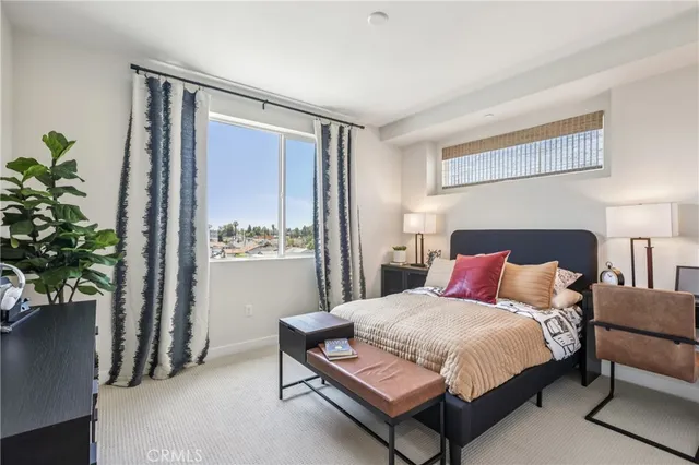 a bedroom with a bed table and a potted plant