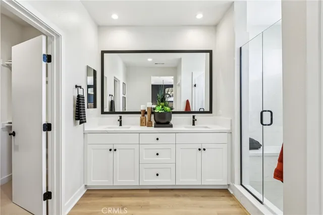 a spacious bathroom with a double vanity sink a mirror and a shower