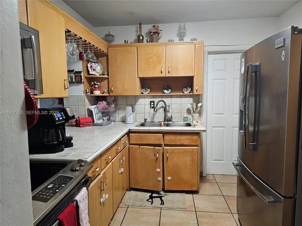 a kitchen with stainless steel appliances a refrigerator sink and cabinets