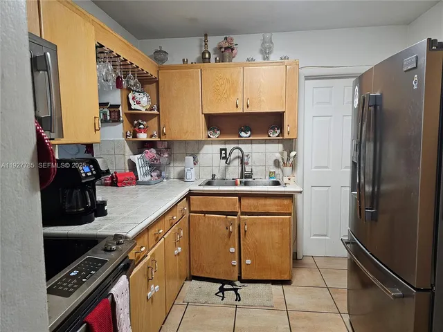a kitchen with stainless steel appliances a refrigerator sink and cabinets