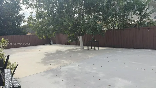 a backyard of a house with table and chairs