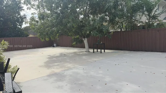 a backyard of a house with table and chairs