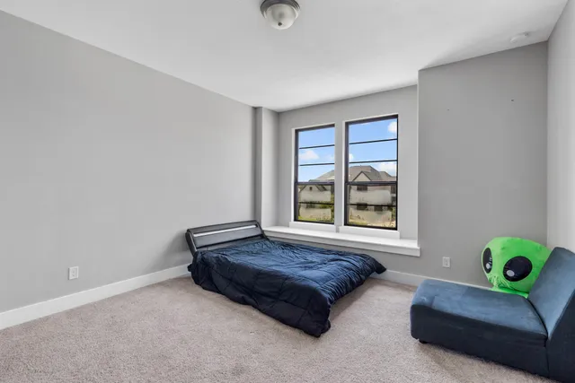 a bedroom with a bed a flat screen tv and a chandelier
