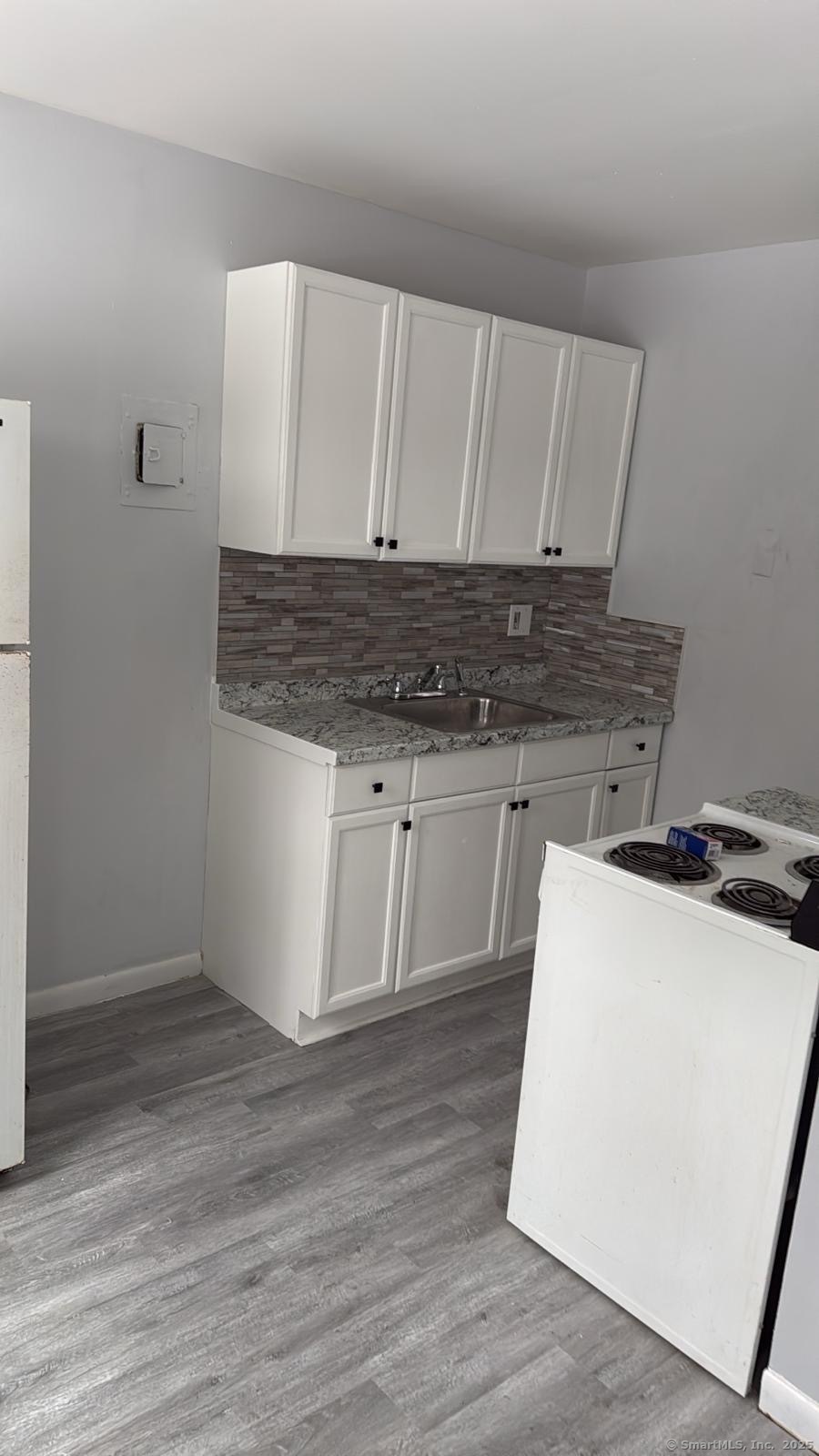 191 Oak Street Bridgeport, CT 06604 - Photo 6 of 7 a kitchen with a stove and white cabinets