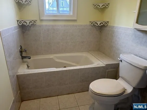 a white toilet sitting next to a bath tub