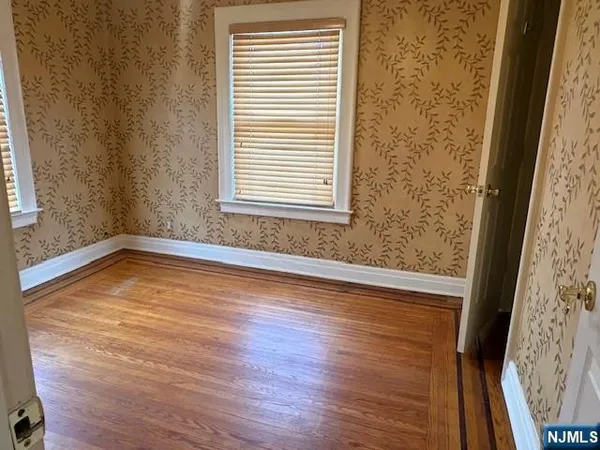 a view of a room with wooden floor and a window