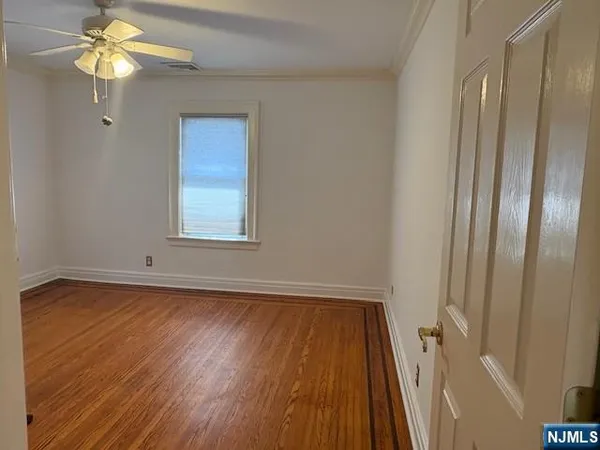 a view of a room with wooden floor and a window