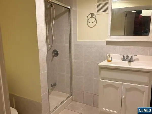 a bathroom with a shower sink and mirror