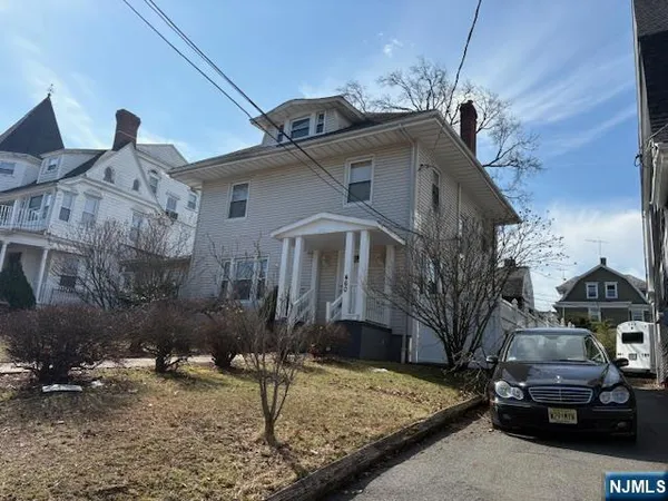 a front view of a house with cars parked