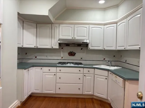 a kitchen with white cabinets and sink