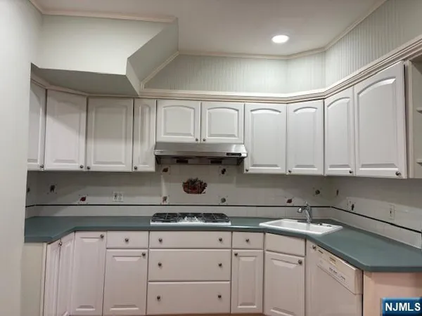 a kitchen with granite countertop white cabinets and sink