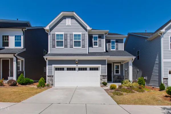 a front view of a house with a yard and garage