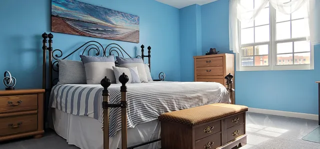 a bedroom with a bed and a painting on the wall