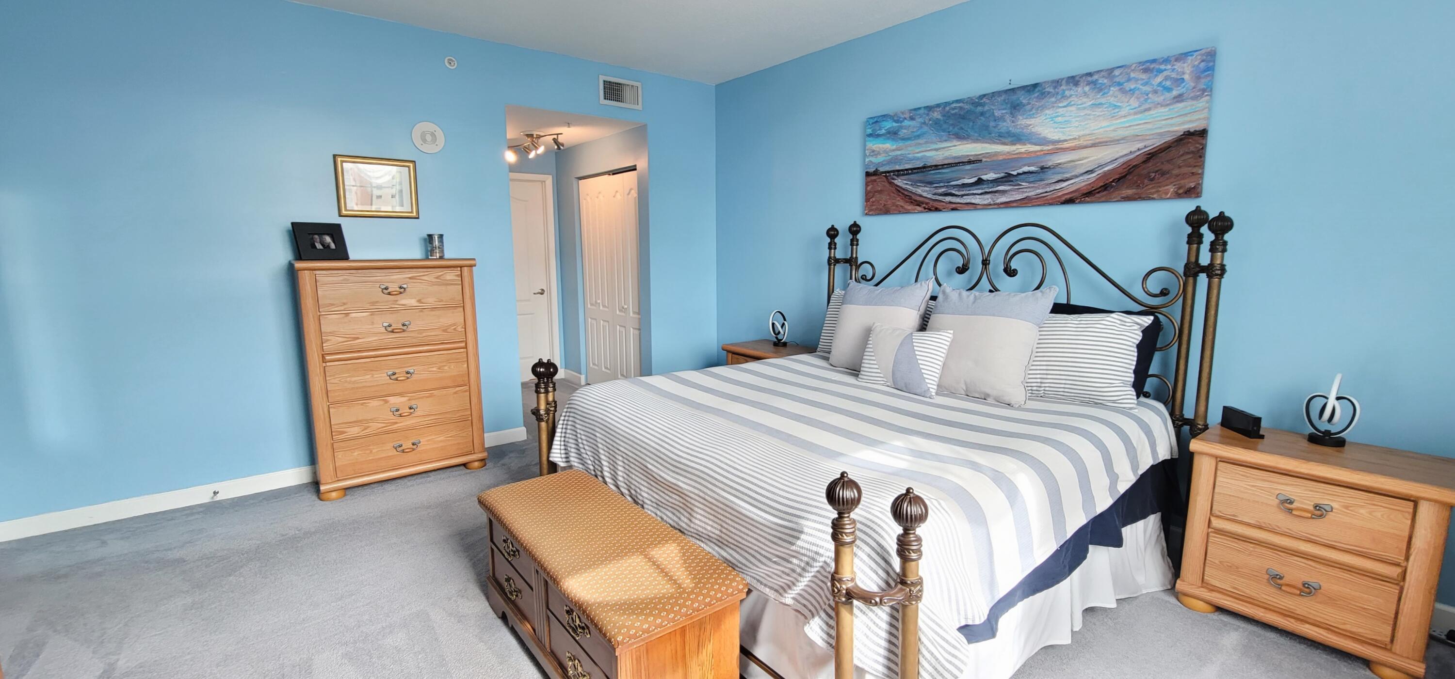 410 Evernia Street, Unit 519 West Palm Beach, FL 33401 - Photo 12 of 27 a bedroom with a bed and a painting on the wall