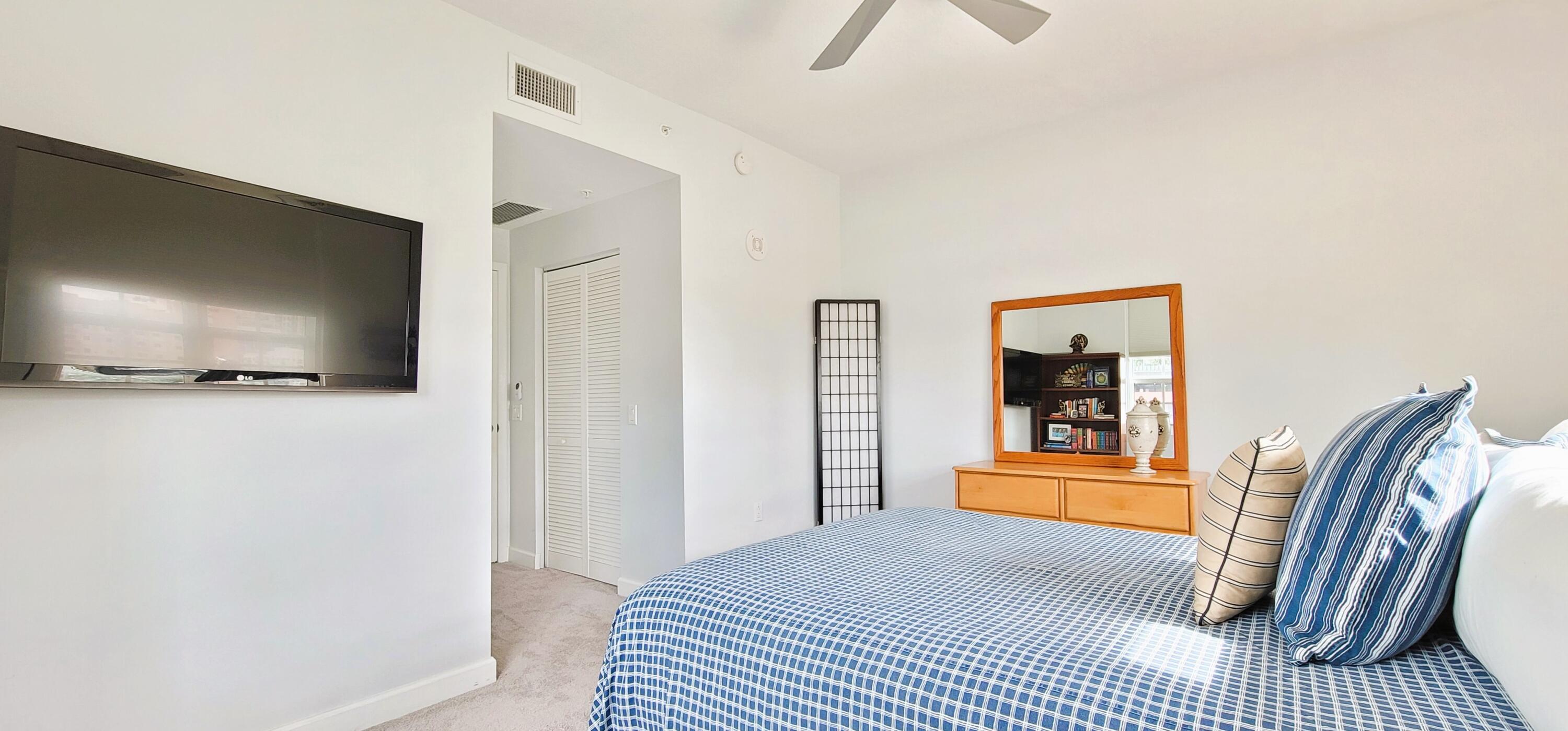 410 Evernia Street, Unit 519 West Palm Beach, FL 33401 - Photo 16 of 27 a bedroom with a bed and a flat screen tv
