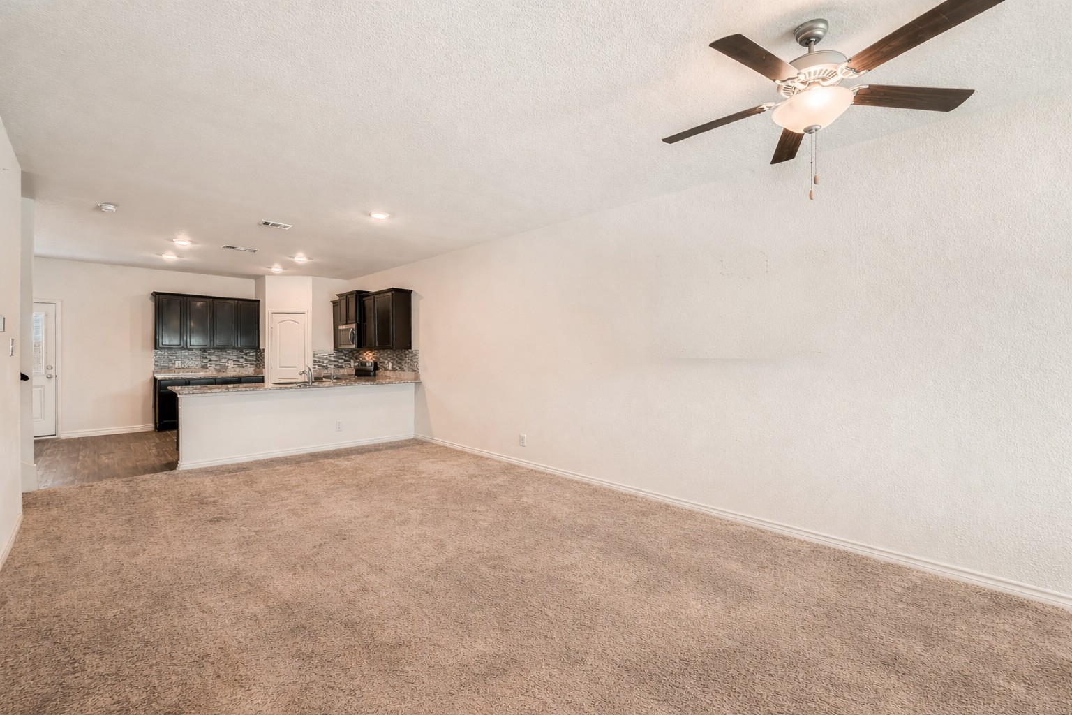 14513 Prairie Sod Lane Elgin, TX 78621 - Photo 4 of 36 a view of a kitchen with a sink and a refrigerator