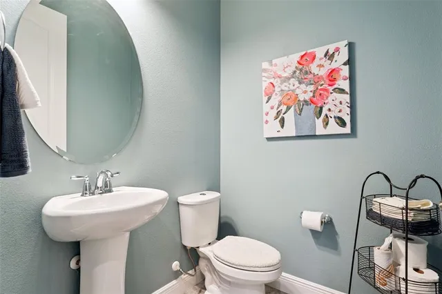 a bathroom with a toilet a sink and mirror
