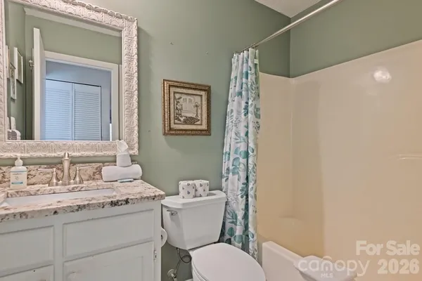 a bathroom with a granite countertop toilet sink and a mirror