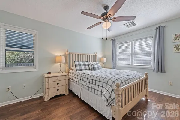 a bedroom with a bed chandelier and a window